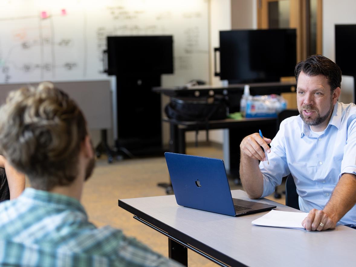 Professor Mitch Ogden, from the English, philosophy and communication studies department, works with a student. He is one of 12 UW-Stout faculty members to receive promotions and tenure.
