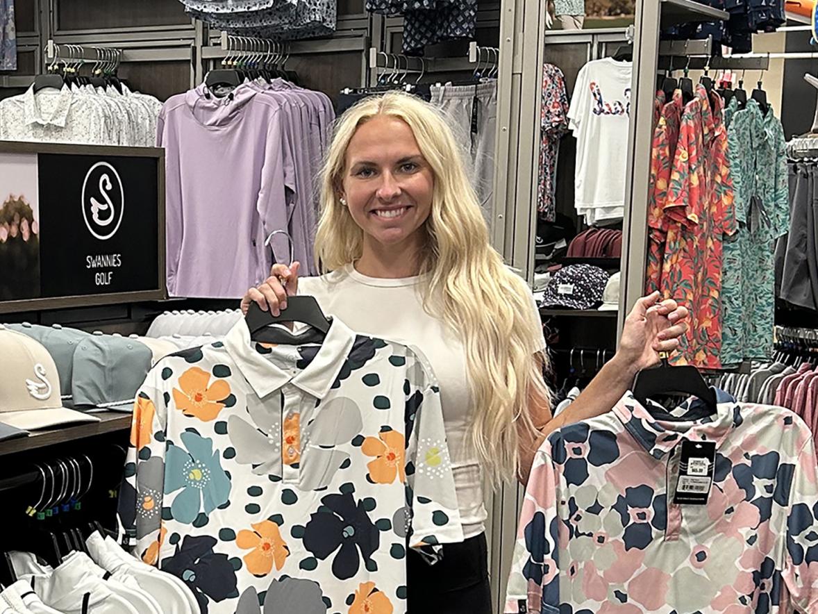 Jessica Cook looks at some of the Swannies Golf apparel she designed and which is on sale at a retail store, one of many across the country that sells the clothing.