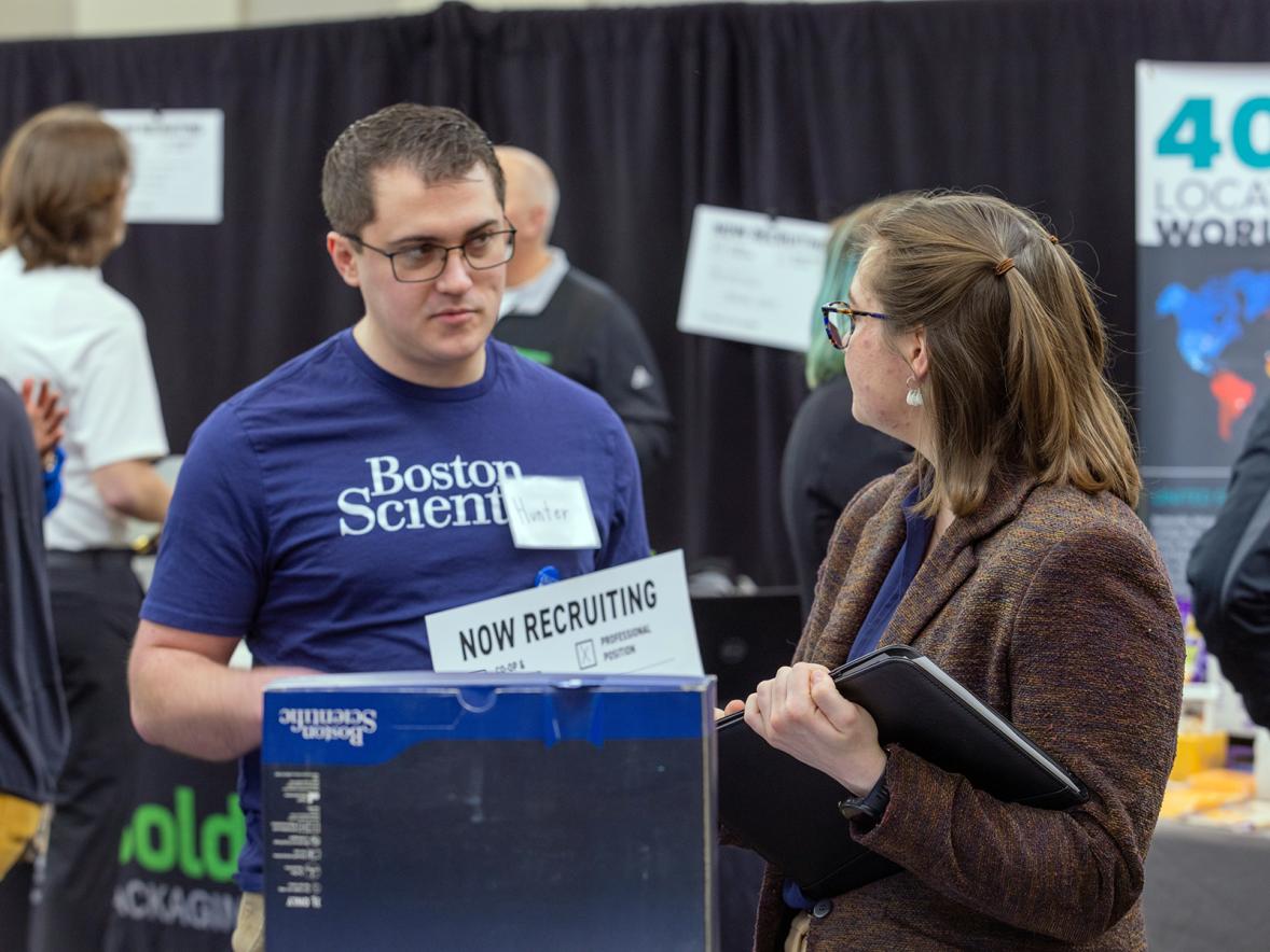 A UW-Stout student meets with a recruiter from Boston Scientific at the Spring Career Conference on campus. Recent graduates reported a $58,000 average starting salary and 99% employment rate.