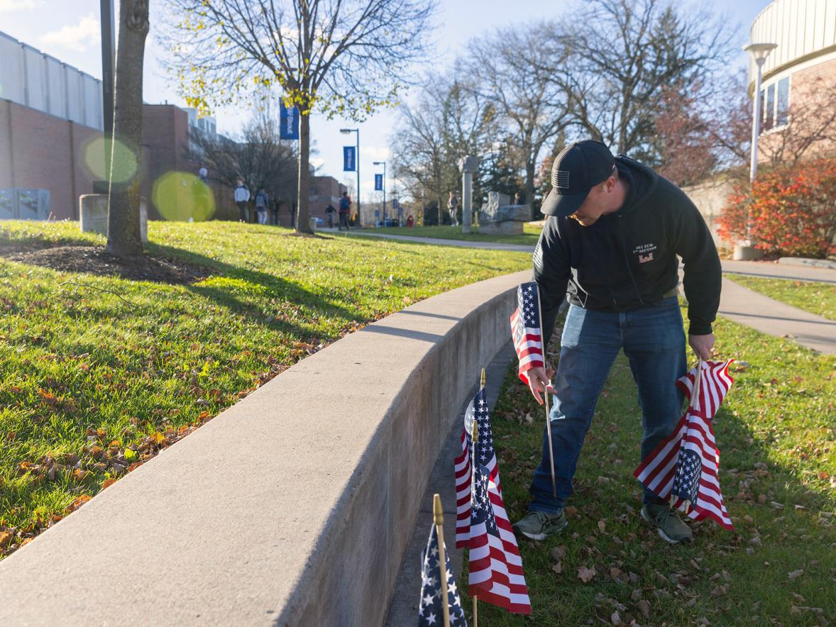A student veteran places flags near the Memorial Student Center on the UW-Stout campus on Nov. 11, 2024.