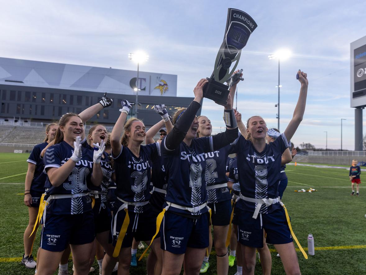 Flag football players celebrate with a trophy
