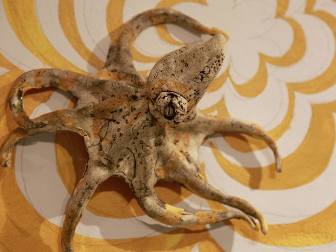 A ceramic octopus on a yellow floral background