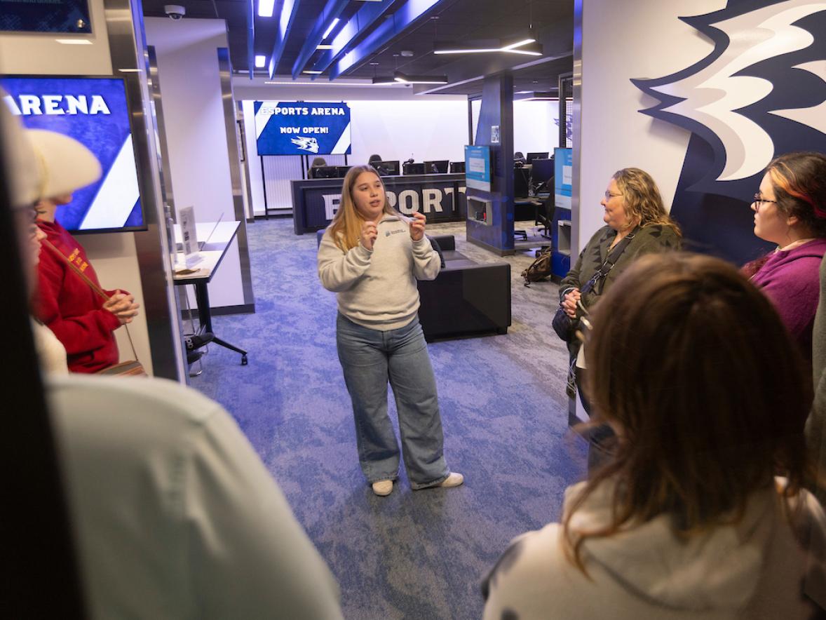 A student gives a group of families a tour of the University Library