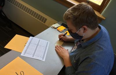 UW-Stout student Andrew Hoepfner fills out toe tags for the art exhibit.