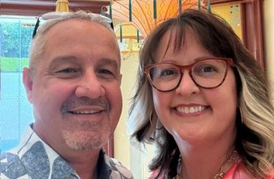 Two people pose together indoors for a selfie-style photo.