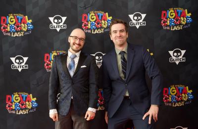 Michael Hilliger and another attendee pose on a red carpet in front of a backdrop for The Amazing Digital Circus: The Last Act.