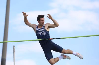 Noah clears a bar during a track and field competition.