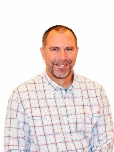 Jeremy Solin, a white man with a buzz cut and facial hair, smiles at the camera
