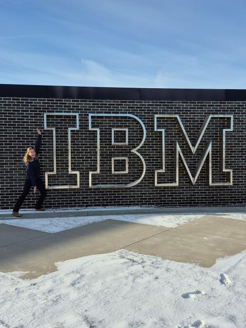 Amber Kuhn stands next to the IBM sign at her place of internship